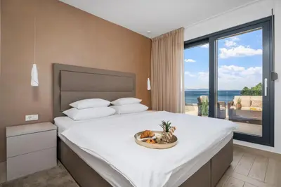 Krevet ili kreveti u jedinici u objektu Luxury, seafront Villa Petra with heated pool only 50m from beach